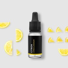 BIO lemon essential oil in black glass bottle with dropper surrounded by fresh yellow lemon slices on white background