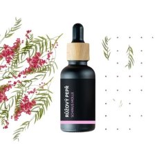 Schwarze Glasflasche mit Holzverschluss, die ätherisches BIO-Rosenpfefferöl enthält, umgeben von zarten rosafarbenen Blüten und grünen Zweigen Schwarze Glasflasche mit Holzverschluss, die ätherisches BIO-Rosenpfefferöl enthält, umgeben von zarten rosafarbenen Blüten und grünen Zweigen
