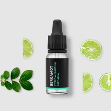 Black glass bottle with dropper containing BIO bergamot essential oil surrounded by fresh lime slices and green leaves